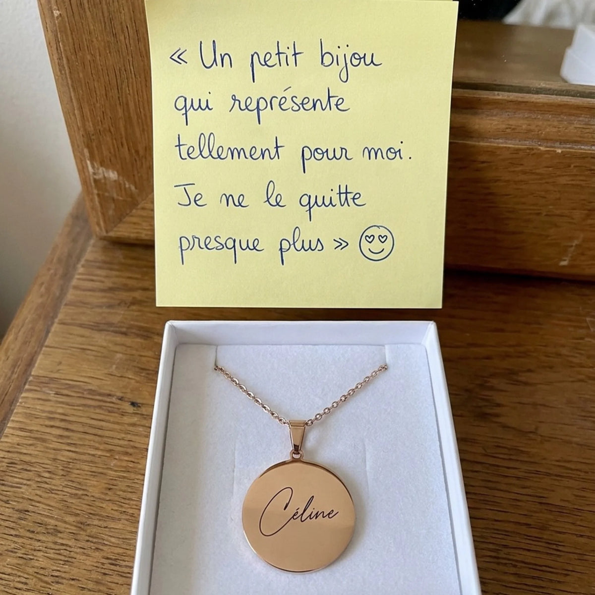 Collier gravé prénom Céline or rose dans son écrin avec un mot de cliente